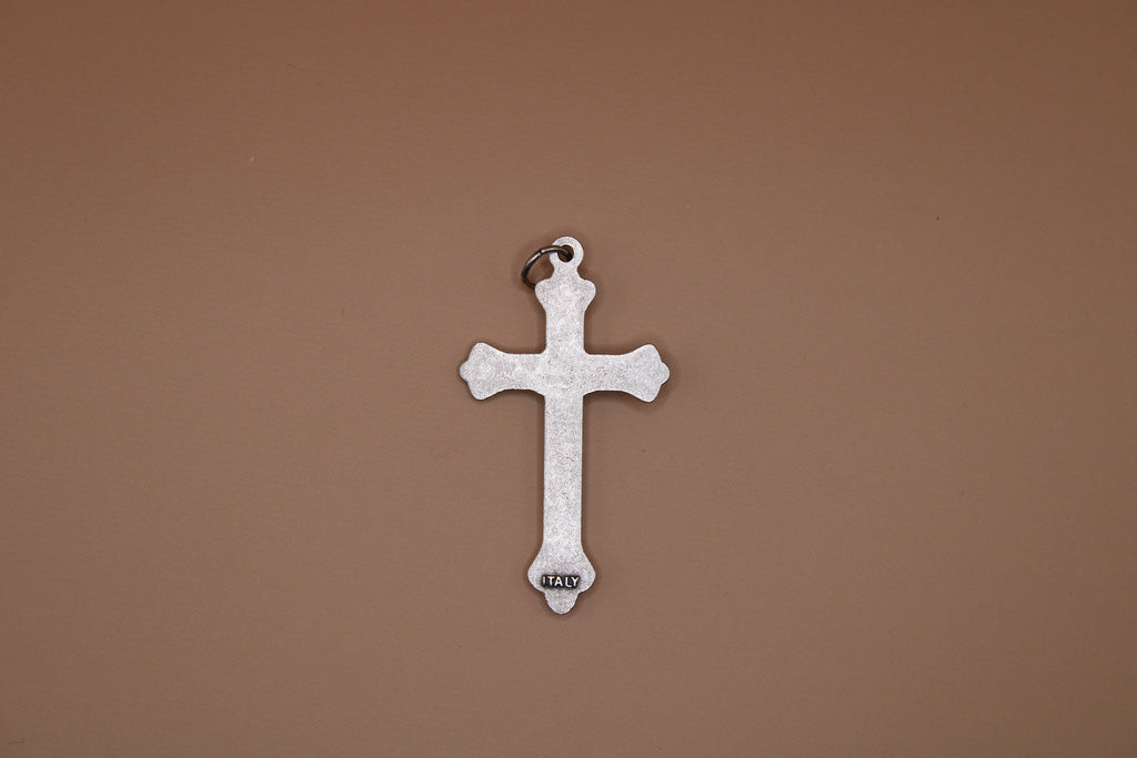 Silver cross pendant on a brown background