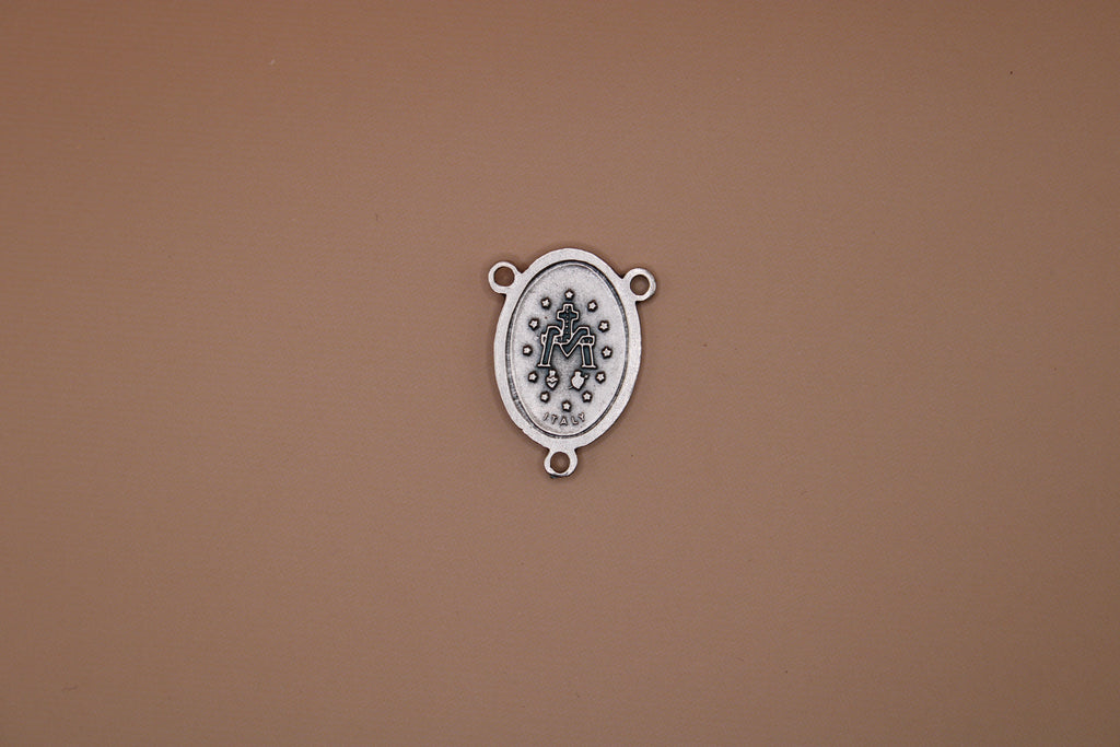 Silver miraculous medal back on a brown background