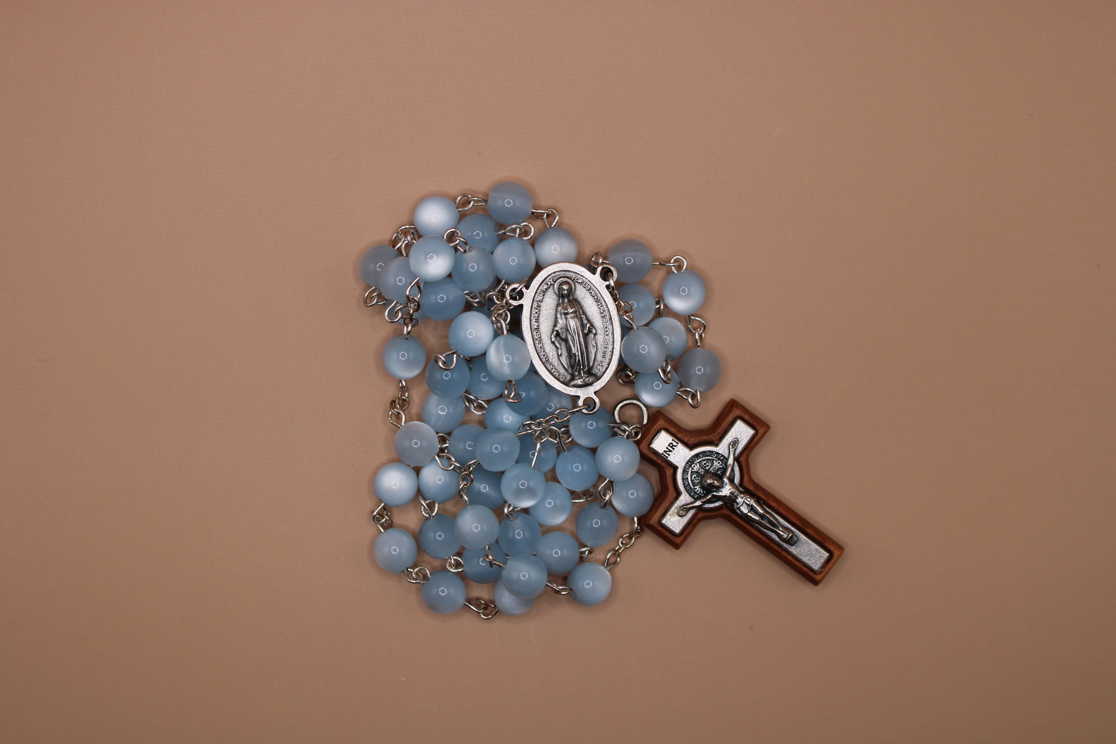 Blue rosary with a cross on a brown background