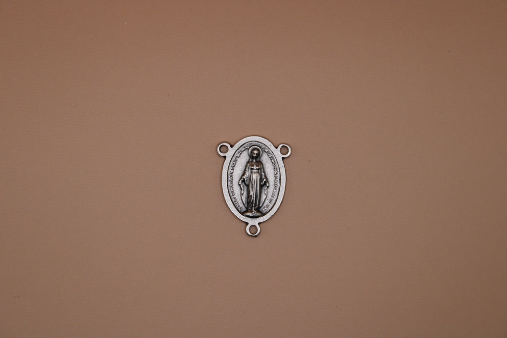 Silver miraculous medal on a brown background