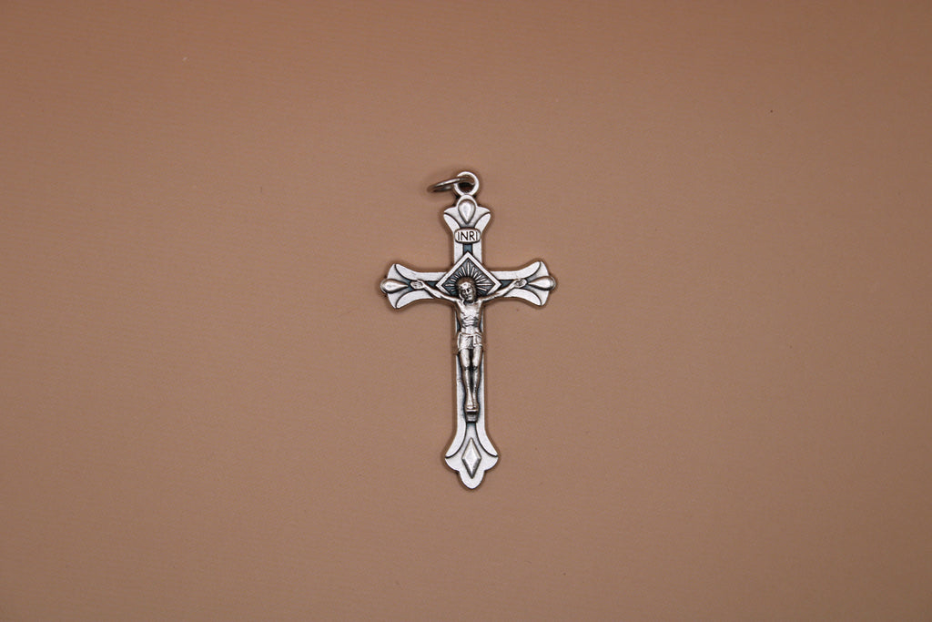 Silver crucifix pendant on a brown background