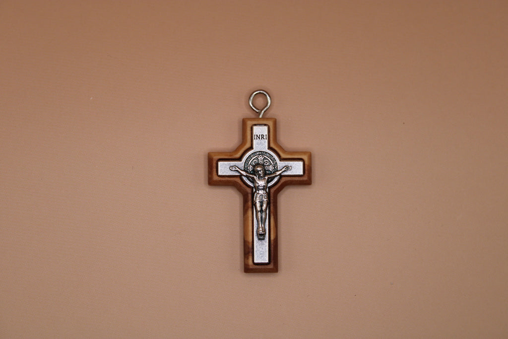 Cross pendant with Jesus Christ figure on a beige background
